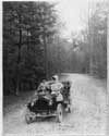 1907 Packard 30 Model U with two passengers in the woods