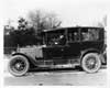1917 Packard limousine with male chauffeur, parked on street, left side view