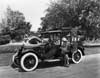 1918 Packard landaulet, parked on street, male driver, two female passengers, one female standing next to car