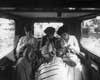 1918 Packard brougham, view from front seat of back seat with three female passengers knitting