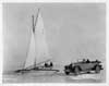1925 Packard touring car parked on frozen lake next to an ice boat