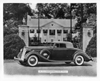 1936 Packard coupe roadster, parked in front of gateway, house in background