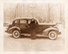1936 Packard touring sedan and woman in fur coat on country road