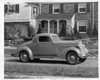 1936 Packard business coupe parked on street in front of house