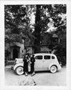 1937 Packard sedan, left side view, parked in front of home, two females standing at driver