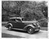 1937 Packard touring sedan parked on drive, female passenger waving