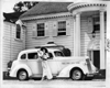 1937 Packard touring sedan with woman in long dress and hat