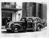 1937 Packard touring sedan in front of Packard Motor Car Co.