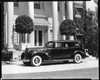 1938 Packard touring sedan, seven-eights left side view, parked in driveway in front of house