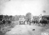 Participants passing through a group of mounted officers, at the 1909 Glidden Tour