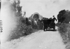 Participants passing covered-wagon in the 1909 Glidden Tour