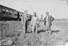 Three Glidden tourists standing near Pullman car in Kearney, Neb., at 1909 Glidden Tour