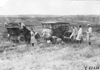 Two women look on as Glidden tourists work on their cars on the Colorado prairie, at 1909 Glidden Tour