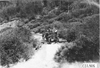Rapid motor truck driving over logs on mountain road in Colo., at 1909 Glidden Tour
