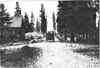 Rapid motor truck passing log cabin on mountain road in Colorado, at 1909 Glidden Tour