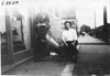 Two men sitting in front of shoe repair shop in Kansas, at 1909 Glidden Tour
