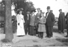 Onlookers pose on sidewalk, at 1909 Glidden Tour