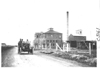 E.M.F. car on rural road passing a factory, on pathfinder tour for 1909 Glidden Tour