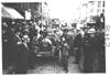 Dai Lewis in E.M.F. car surrounded by a group of men and boys, on pathfinder tour for 1909 Glidden Tour