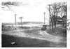 E.M.F. car rounding corner by lake, on pathfinder tour for 1909 Glidden Tour