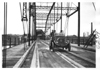 E.M.F. car crossing a large, iron bridge, on pathfinder tour for 1909 Glidden Tour