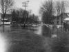 Flooded residential area with man in boat, Lansing, 1904
