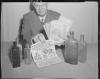 Man holding antiques ads and bottles