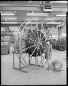 Woman standing by large hose reel in warehouse