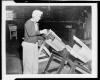 Woman worker packing parachute into cylinder