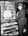 Male clerk at drugstore helping male customer