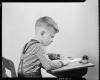 School boy writing at desk