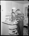 Man demonstrating counter top product to woman in kitchen