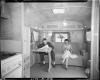 Man and woman seated on couch in Kozy Coach trailer
