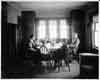 Family seated around dining room table, photograph part 1