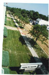 Taken from the southeast roof atop Fisher Body building 3X looking north along Verlinden Ave in summer 1998.  The two story white building seen above the trees in the upper right of the photo is Harry’s Bar.  The street is gravel as it is being resurfaced.