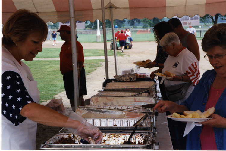 image of Sally Grubaugh serving food at the picnic.